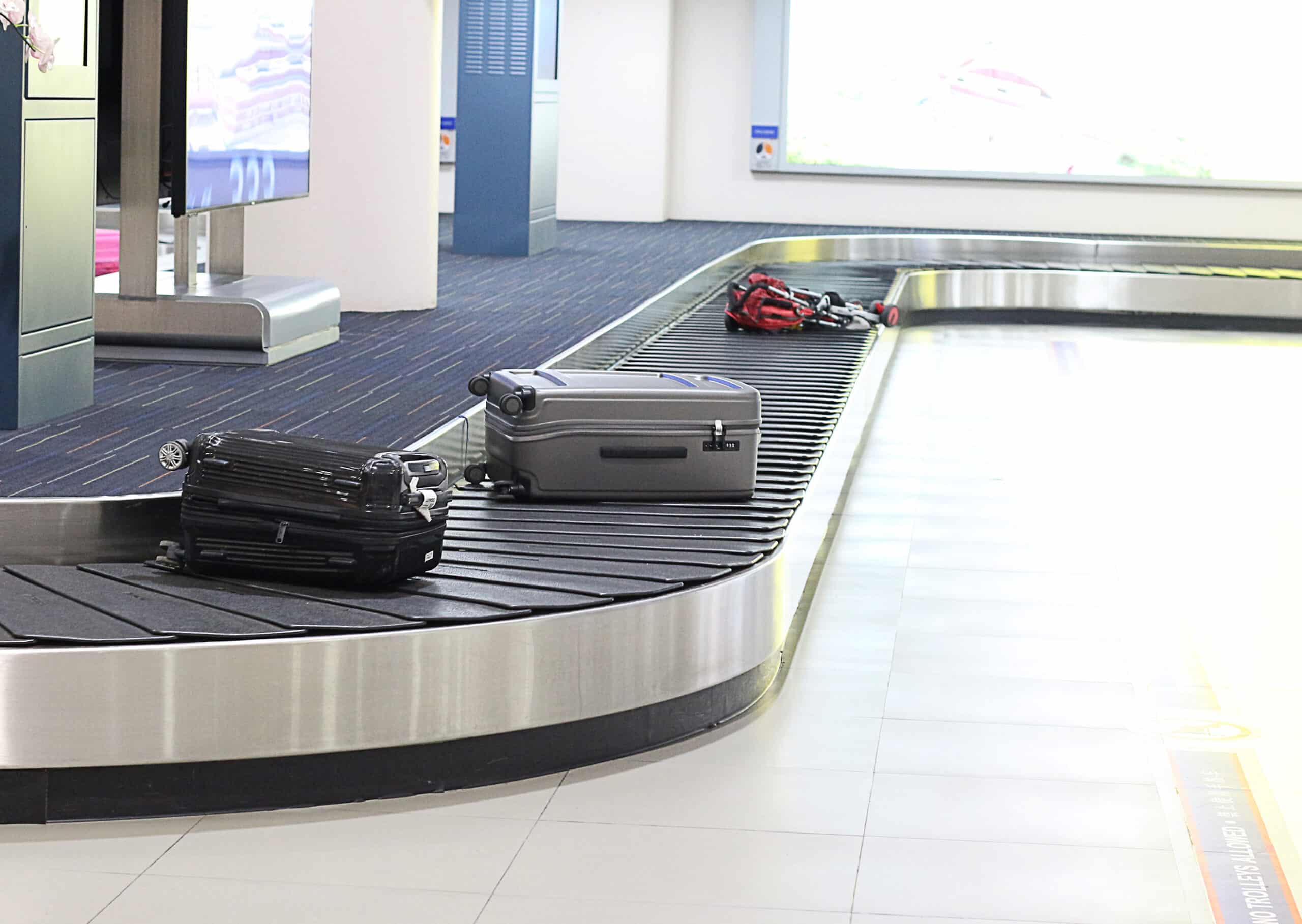 Luggage on a roller conveyor belt at the airport terminal.